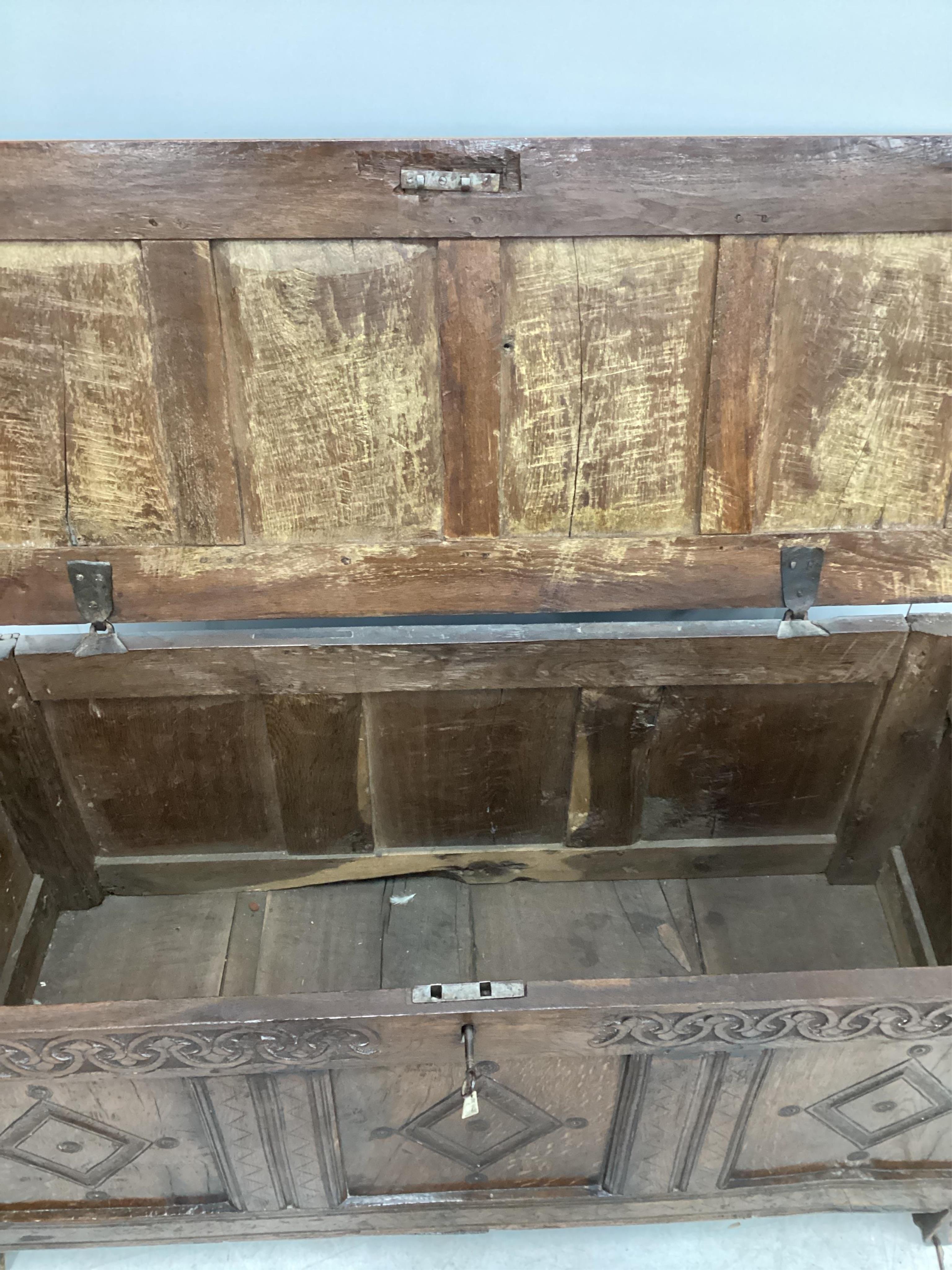 A late 17th / early 18th century panelled oak coffer, width 126cm, depth 51cm, height 62cm. Condition - fair, one top panel split, front probably later carved.